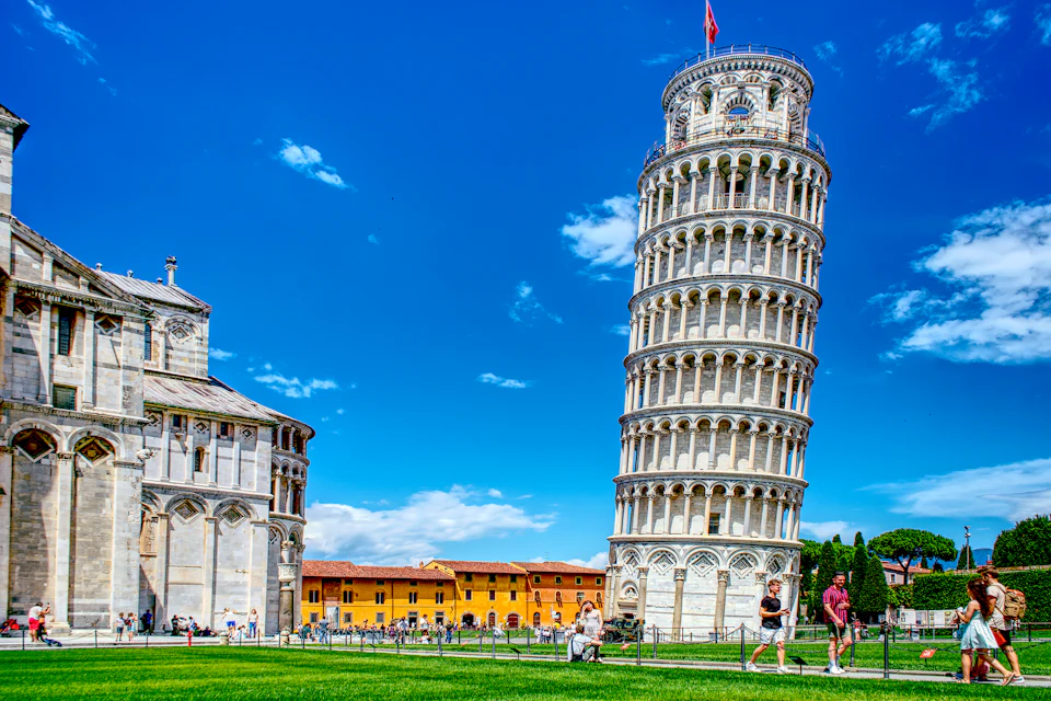 La Torre di Pisa con visitatori sul prato in una giornata di sole
